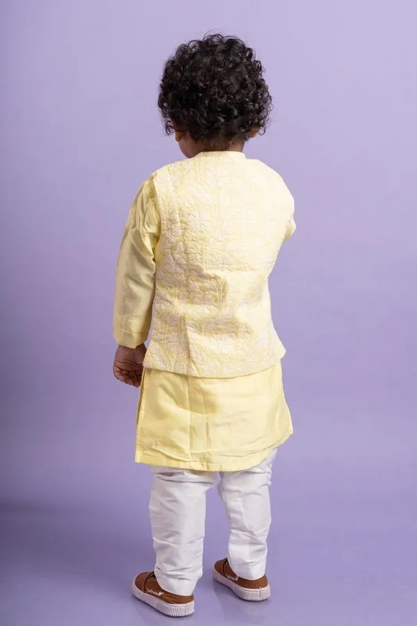 Elegant soft yellow kurta with intricate white embroidery, paired with classic white churidar pants for a timeless festive look